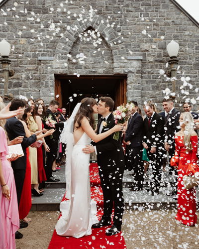 Couple kiss on their wedding day outside chapel at ballyseede castle hotel