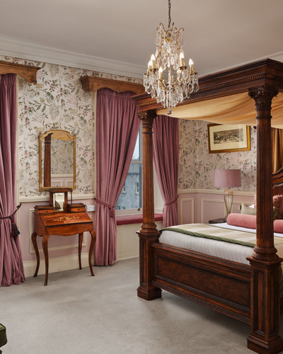 Luxury castle hotel room with chandelier and four post bed